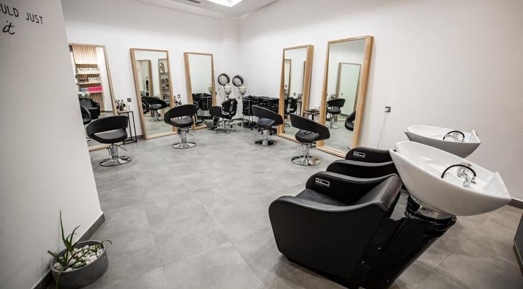Modern salon interior at Stone Beauty Centre, Sharjah, AE, featuring stylish chairs and washbasins.