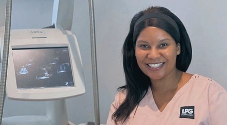 Smiling therapist beside Endermologie machine at Endermologie & Slimming, SOMERSET WEST, Western Cape, ZA.