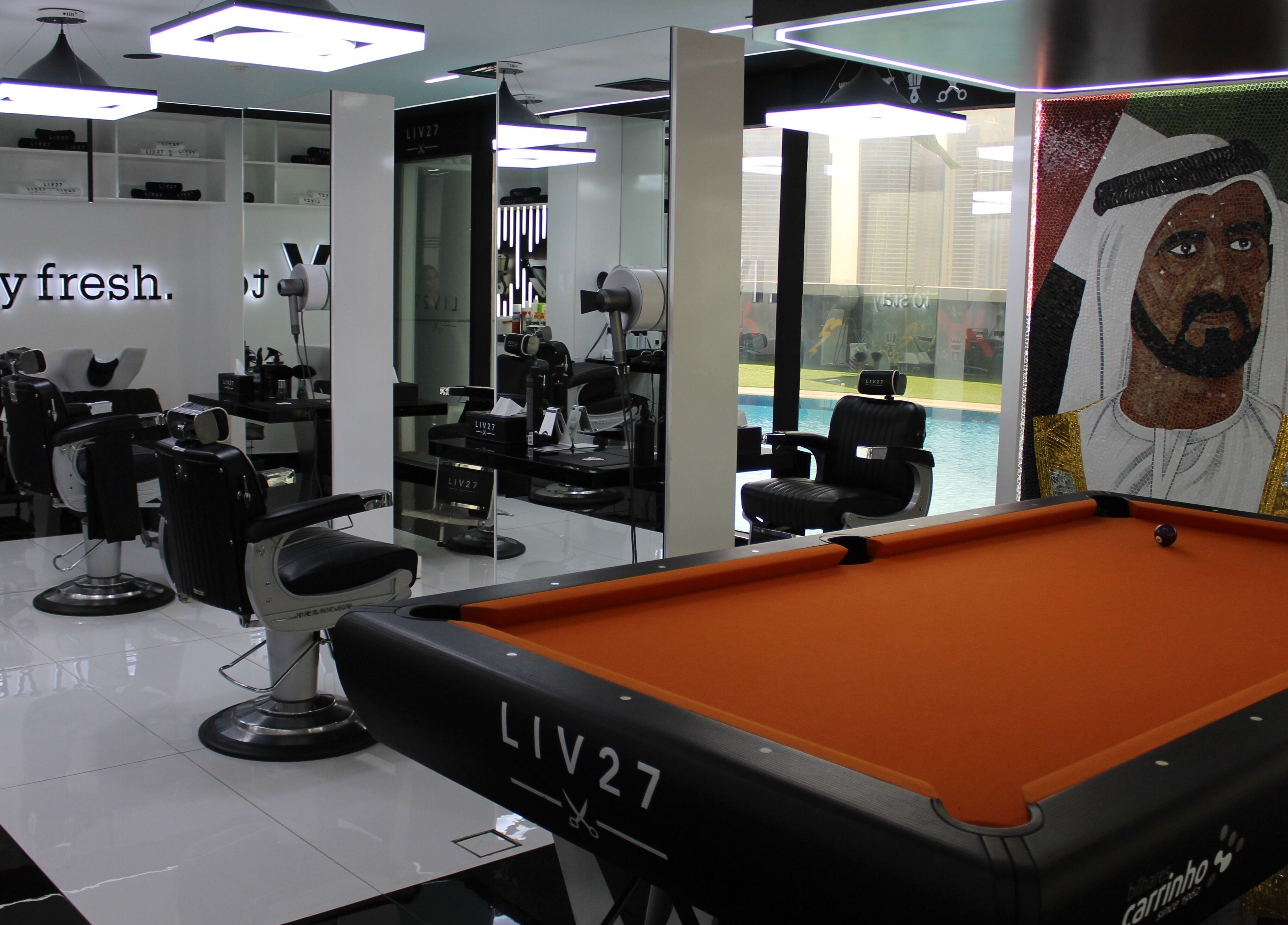 Stylish interior of LIV27 - Media City Branch in Dubai, Dubai, AE, featuring pool table and grooming chairs.