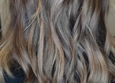 Elegant wavy hairstyle at Ahead of Hair, Sandton, Gauteng, ZA, showcasing vibrant color and shine.