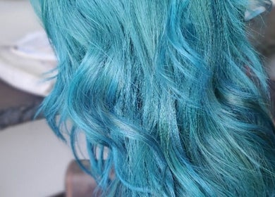 Vibrant turquoise hair waves styled at Ahead of Hair, Sandton, Gauteng, ZA, showcasing unique salon artistry.