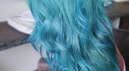 Vibrant turquoise hair waves styled at Ahead of Hair, Sandton, Gauteng, ZA, showcasing unique salon artistry.