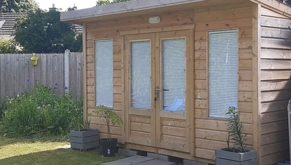 Wooden cabin at The Beauty Garden in Bray, County Wicklow, IE, surrounded by greenery.