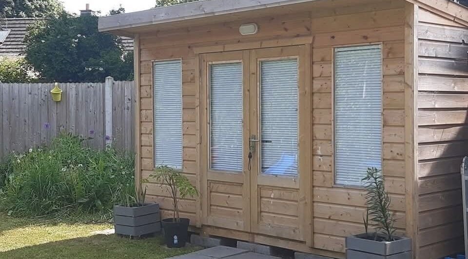 Wooden cabin at The Beauty Garden in Bray, County Wicklow, IE, surrounded by greenery.