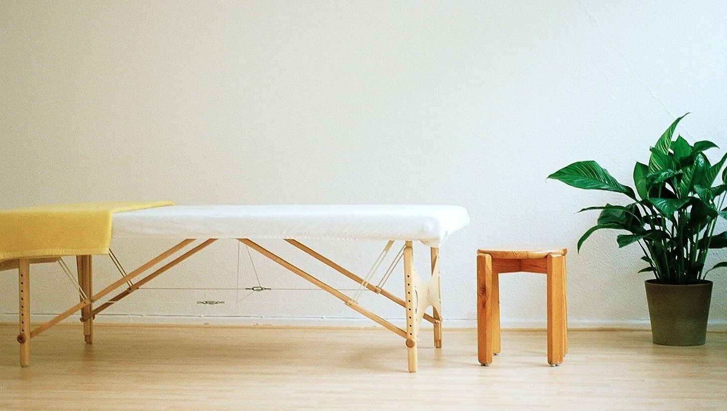 Luftiger Massageraum mit Liege und Pflanze bei Body Mind Academy, Kiel, Schleswig-Holstein, DE.