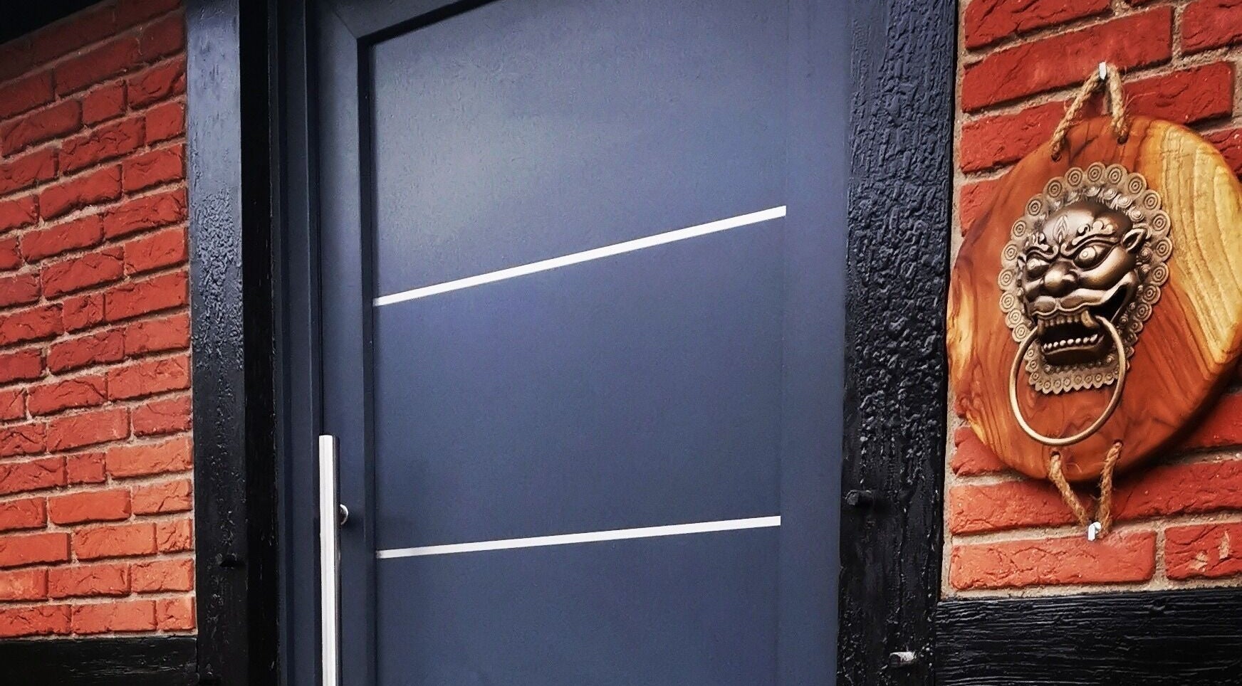 Eingang der Body Mind Academy in Kiel, Schleswig-Holstein, DE mit dekorativem Löwen-Türklopfer.