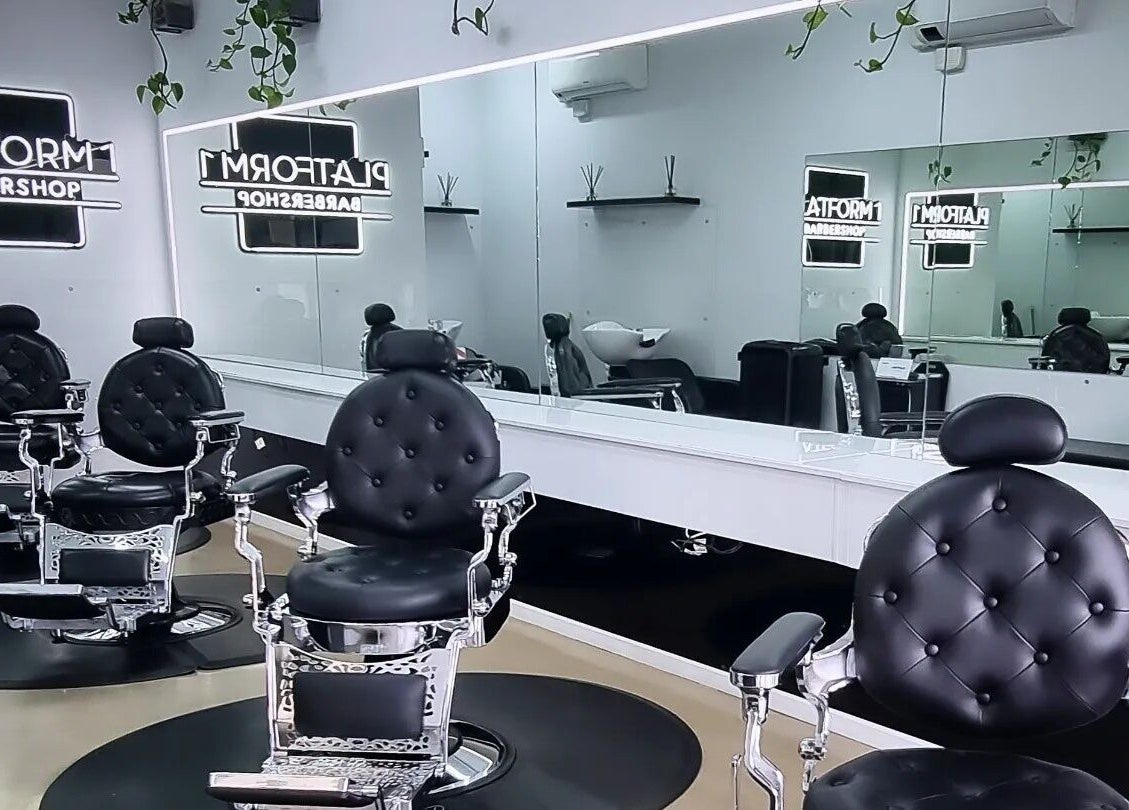 Stylish interior of Platform 1 Barbershop in Seaton, South Australia showcasing sleek black chairs and modern decor.
