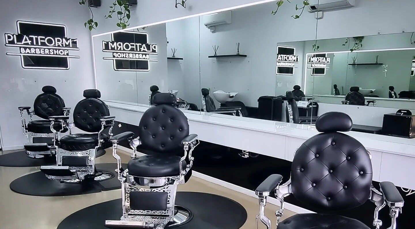 Stylish interior of Platform 1 Barbershop in Seaton, South Australia showcasing sleek black chairs and modern decor.