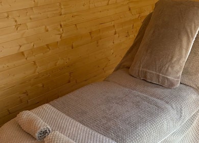 Relaxing therapy bed setup at Rio Bluebell Therapies, Salisbury, England, GB, with soft bedding and warm lighting.