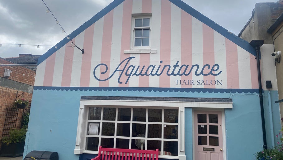 Charming facade of Aquaintance Hair Salon in Darlington, England, GB with striped pastel colors.