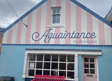 Charming facade of Aquaintance Hair Salon in Darlington, England, GB with striped pastel colors.