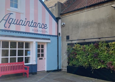 Outside view of Aquaintance Hair Salon with a pink bench in Darlington, England, GB.