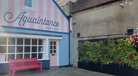Outside view of Aquaintance Hair Salon with a pink bench in Darlington, England, GB.