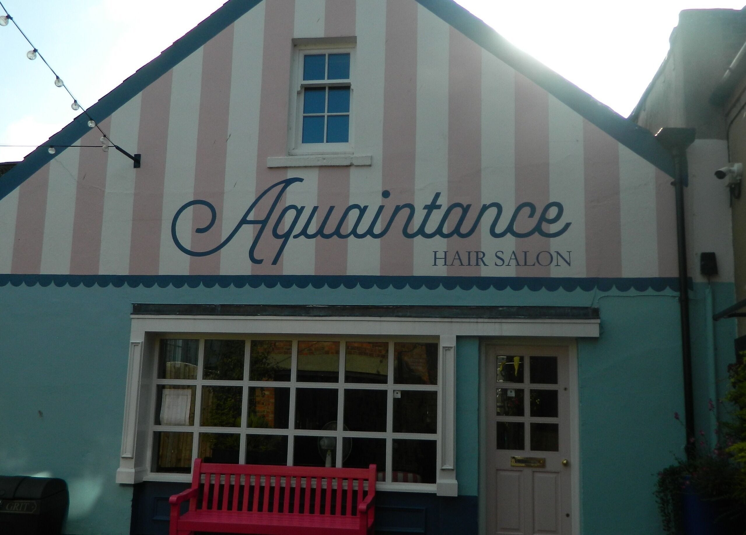 Charming facade of Aquaintance Hair Salon in Darlington, England, GB with pastel hues and a welcoming bench.