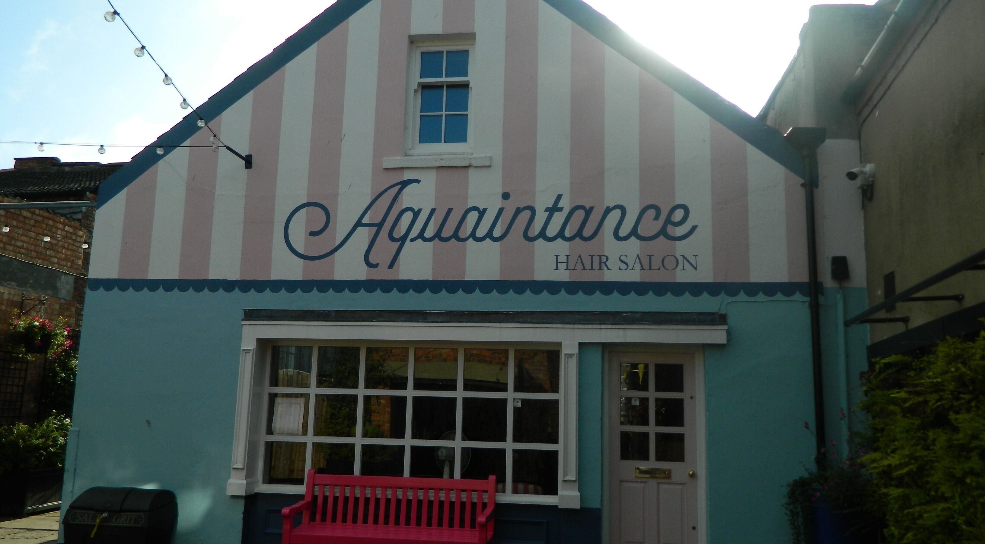 Charming facade of Aquaintance Hair Salon in Darlington, England, GB with pastel hues and a welcoming bench.