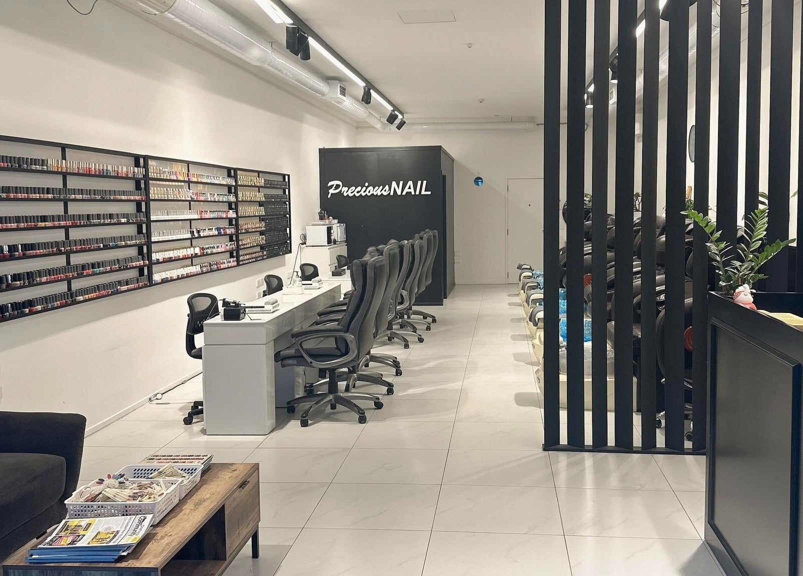 Modern nail salon interior at Precious Nail, Auckland, Auckland, NZ with sleek chairs and polish display.