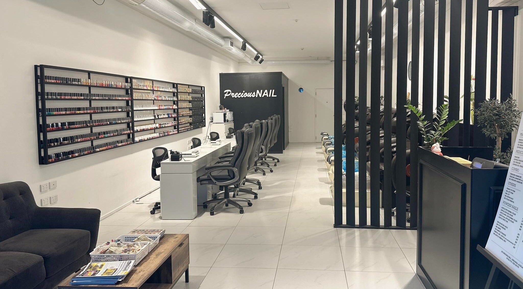 Modern nail salon interior at Precious Nail, Auckland, Auckland, NZ with sleek chairs and polish display.
