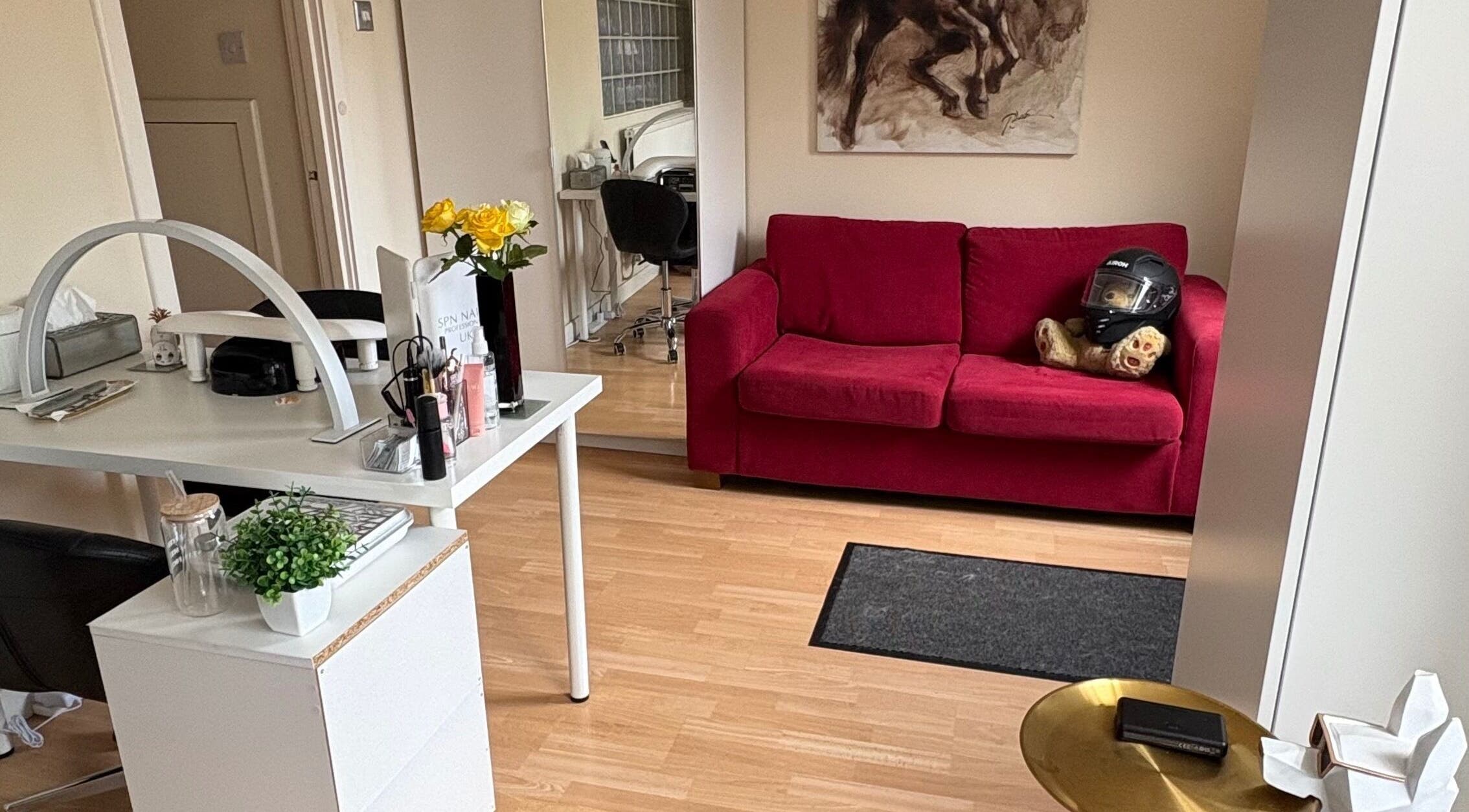 Cozy reception with red couch at Nails By Sonya Stark in Leeds, England, GB showcasing modern decor.