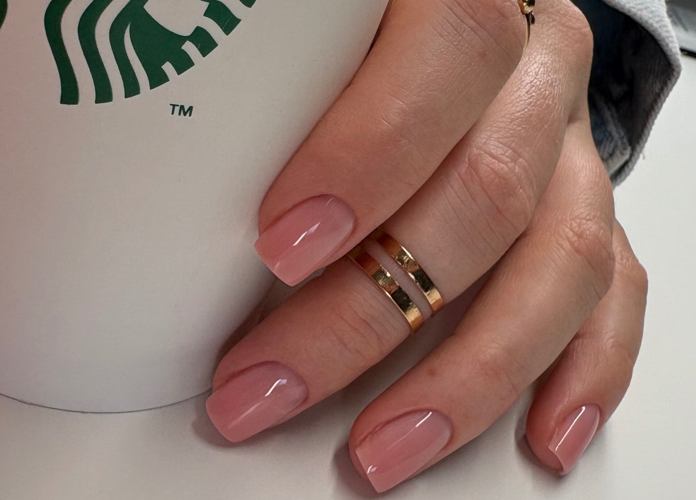 Elegant pink manicure at Nails By Sonya Stark, Leeds, England, GB, holding a coffee cup.