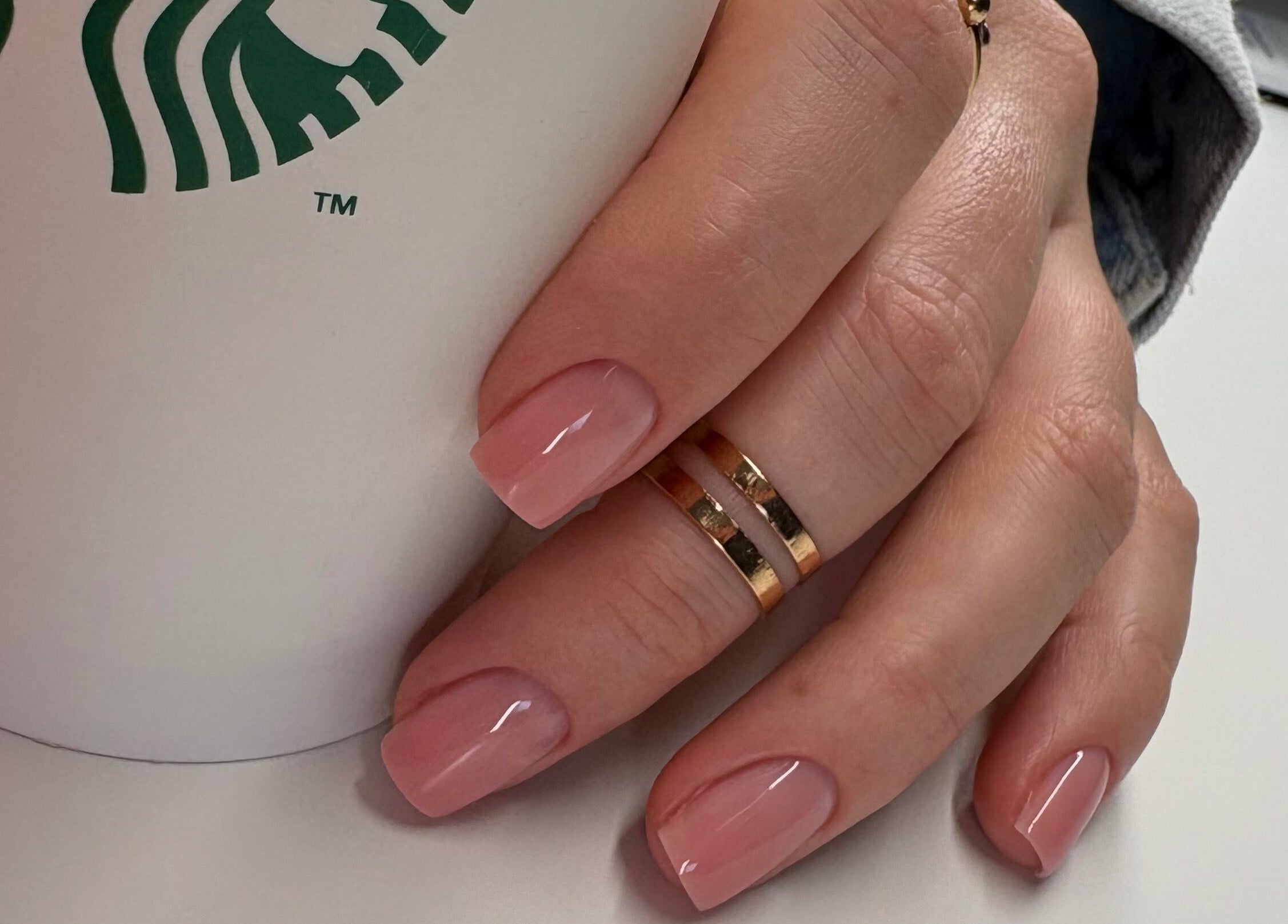 Elegant pink manicure at Nails By Sonya Stark, Leeds, England, GB, holding a coffee cup.