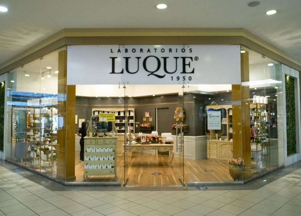 Entrada iluminada de Laboratorios Luque Ceibos en Guayaquil, Guayas, EC, destacando productos de belleza.