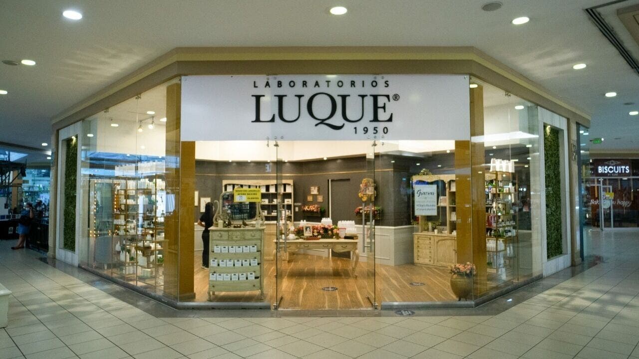 Entrada iluminada de Laboratorios Luque Ceibos en Guayaquil, Guayas, EC, destacando productos de belleza.