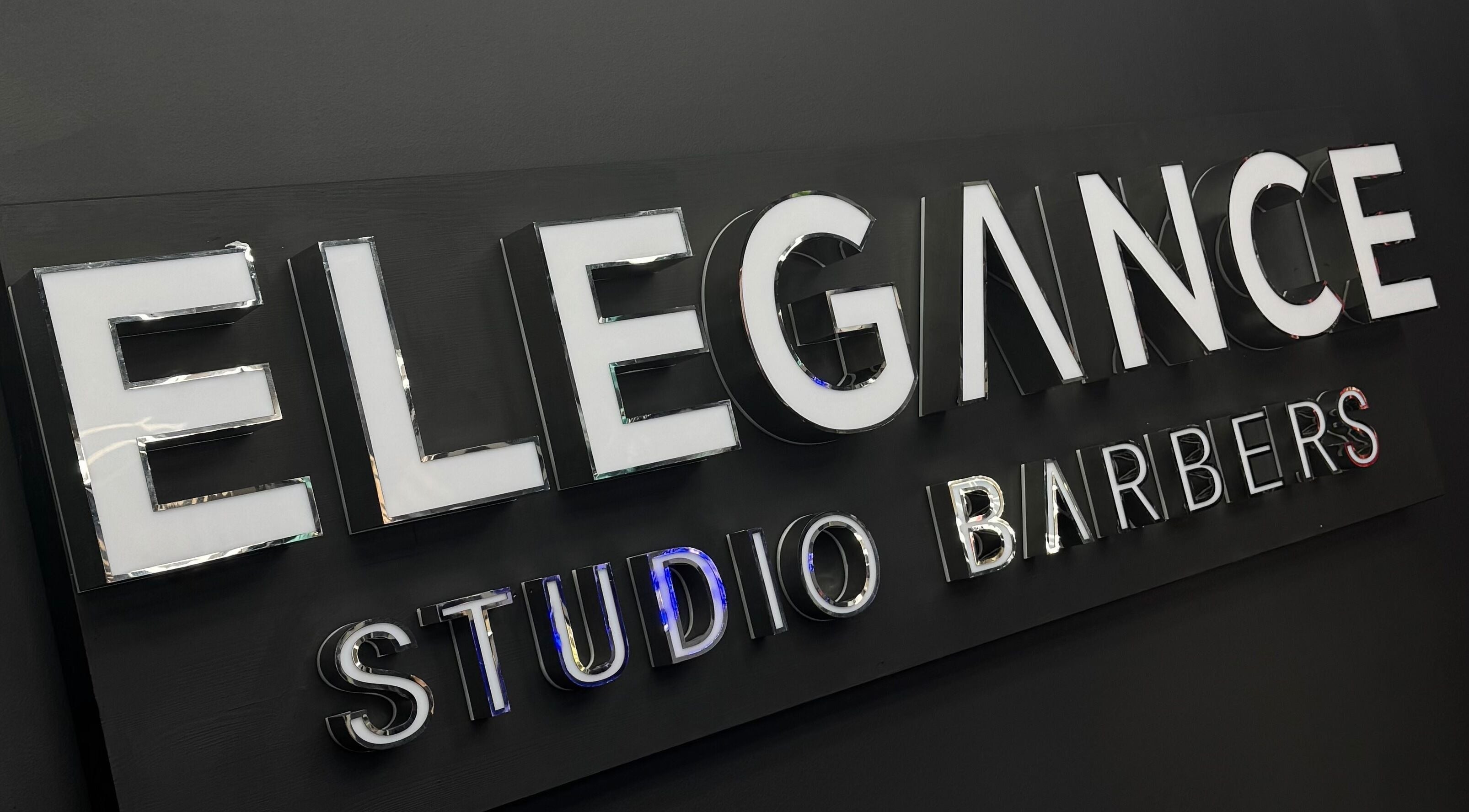 Signage of Elegance Studio Barbers in Paphos, CY, showcasing modern design.