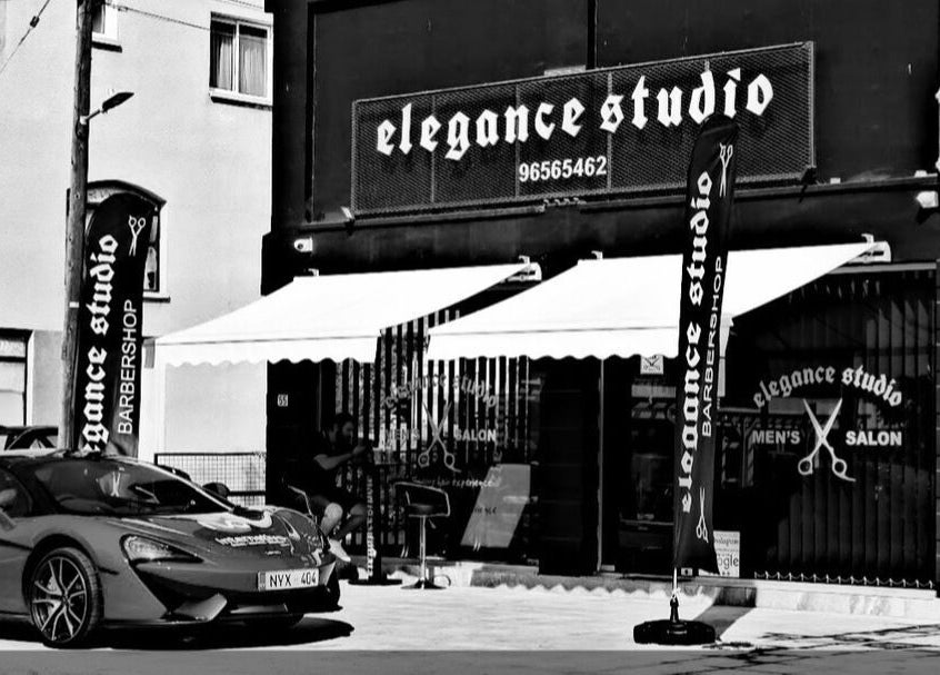 Exterior of Elegance Studio Barbers, Paphos, CY showcasing its stylish black facade and branding.