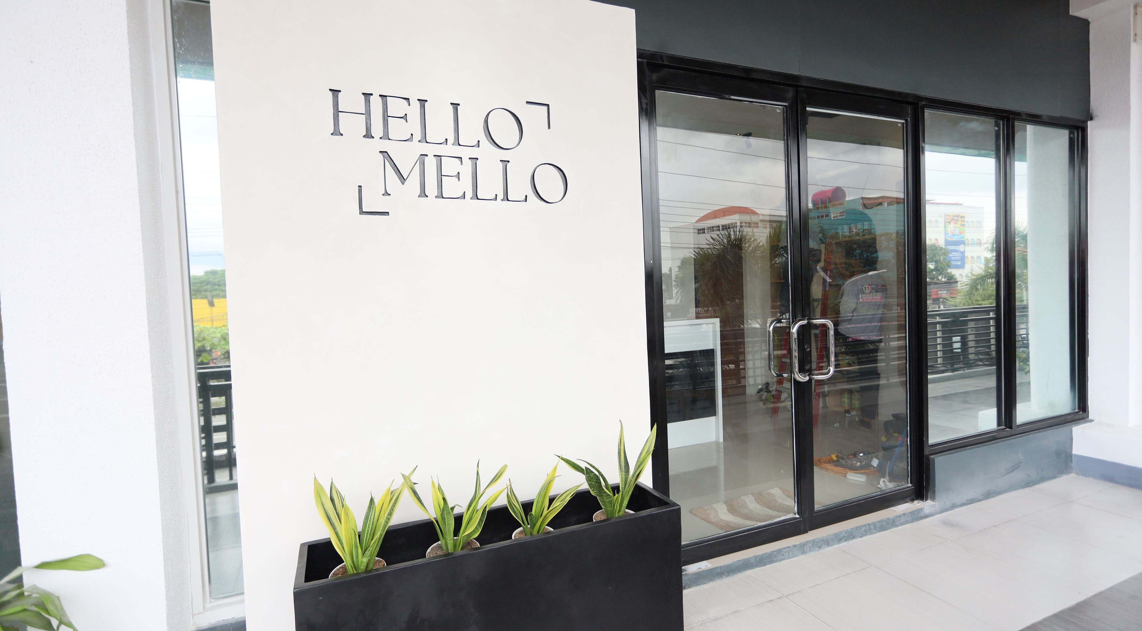 HelloMello Salon entrance in Angeles, Central Luzon, PH with modern glass doors and greenery.