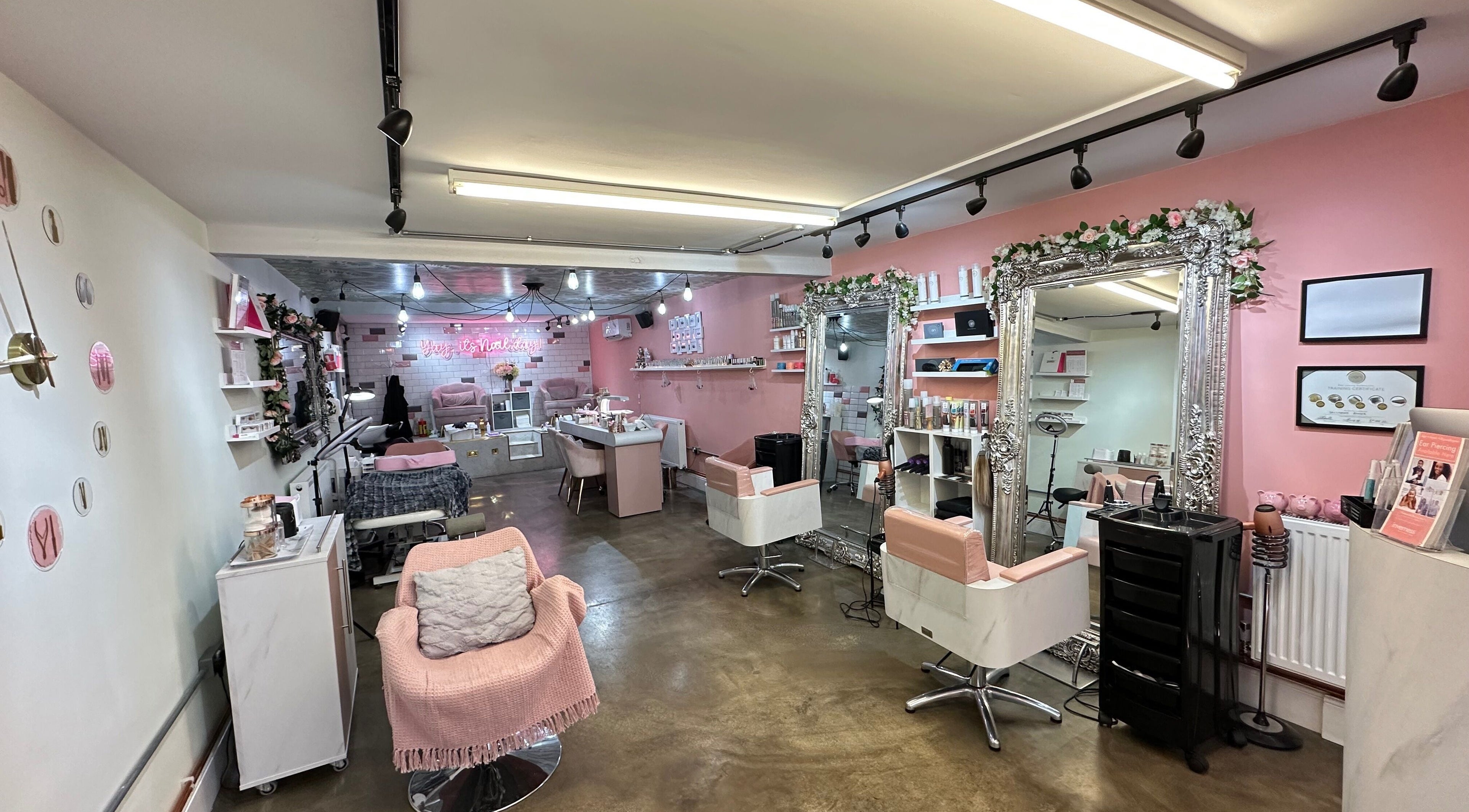 Trendy interior of Worlds End Hair & Beauty salon, Burgess Hill, England, GB, with pink decor and stylish mirrors.