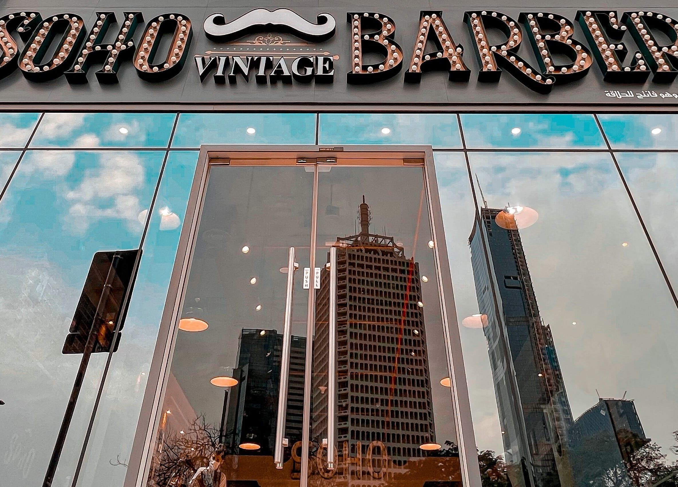 Reflection of cityscape on glass facade of Soho Vintage Barbers | Sheikh Zayed Road, Dubai, Dubai, AE.