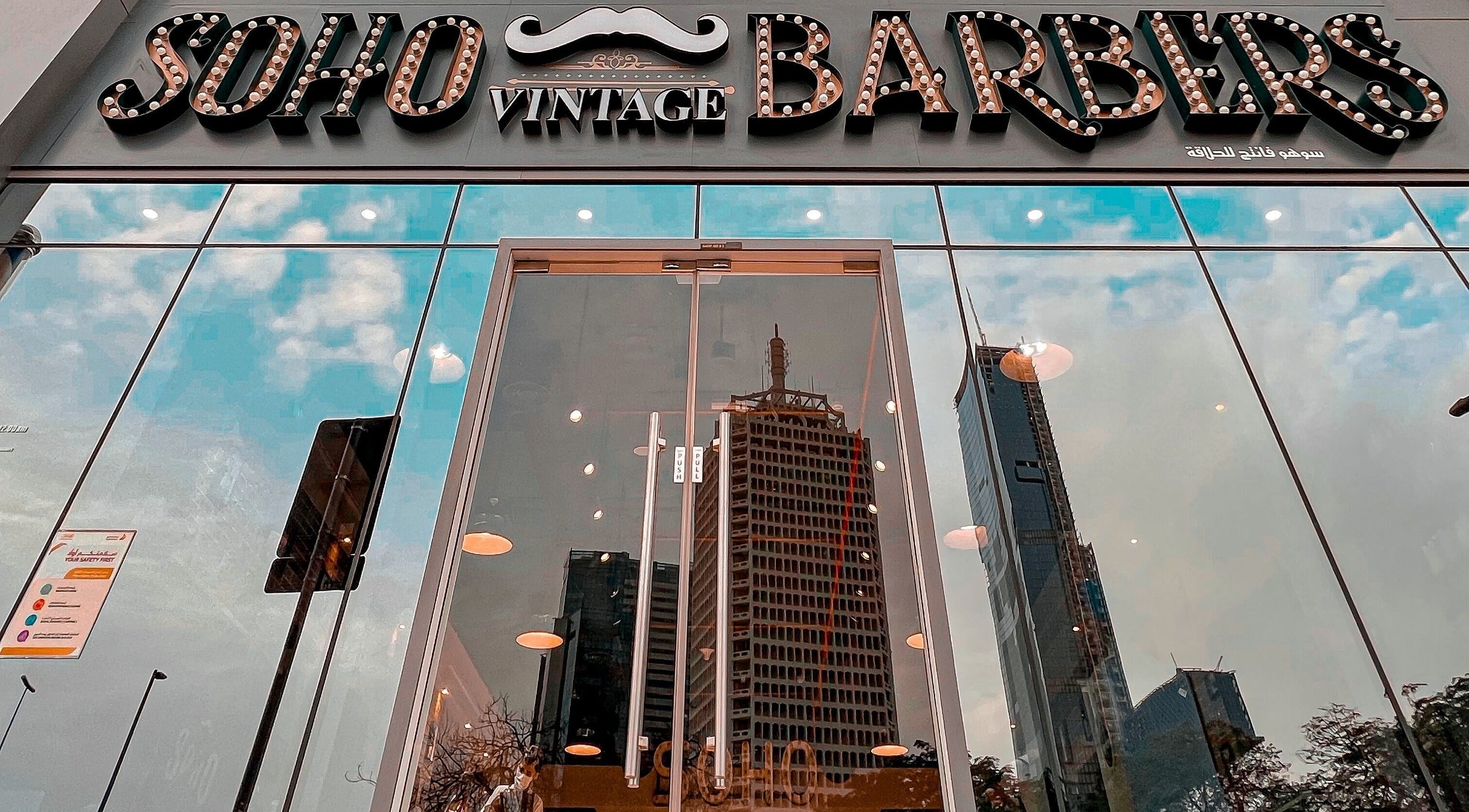 Reflection of cityscape on glass facade of Soho Vintage Barbers | Sheikh Zayed Road, Dubai, Dubai, AE.