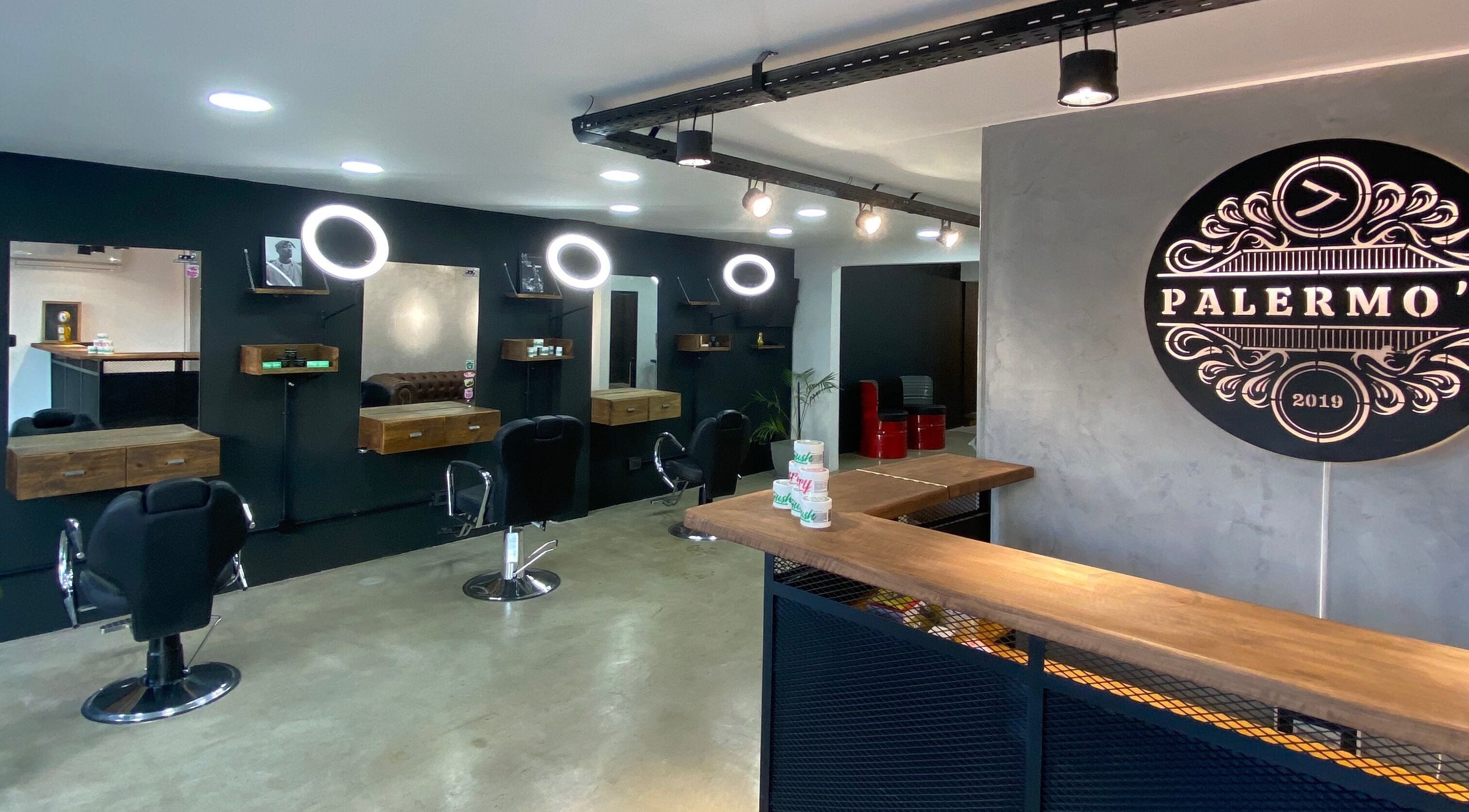 Interior moderno de Barberia Palermo's, Castelar, Provincia De Buenos Aires, AR, con espejos y sillas negras.