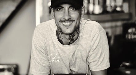 Empleado sonriente en Homo Elegans Club, Puente Genil, Andalucía, ES, ofreciendo un ambiente cálido.
