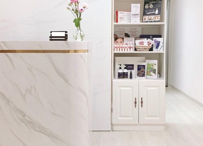 Elegant marble reception at Dear Gals Beauty in Hong Kong, HK, featuring chic decor and beauty products.