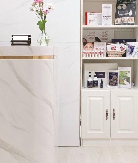 Elegant marble reception at Dear Gals Beauty in Hong Kong, HK, featuring chic decor and beauty products.