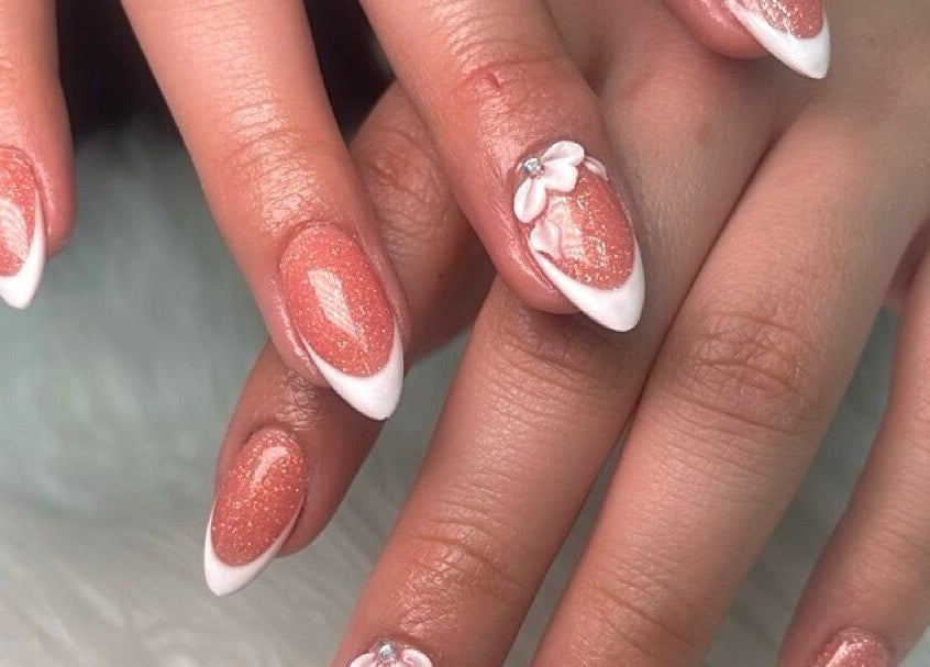 Elegant pink glitter nails with floral art at Ava Nail Bar Geneva in Geneva, Illinois, US.