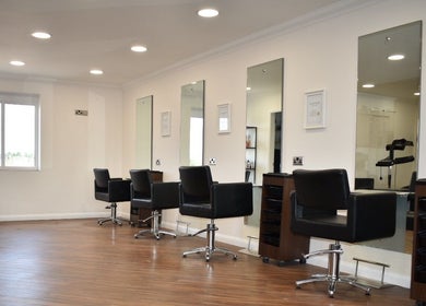 Modern salon interior at Escape Hair, Strensall, England, GB featuring sleek styling stations and mirrors.