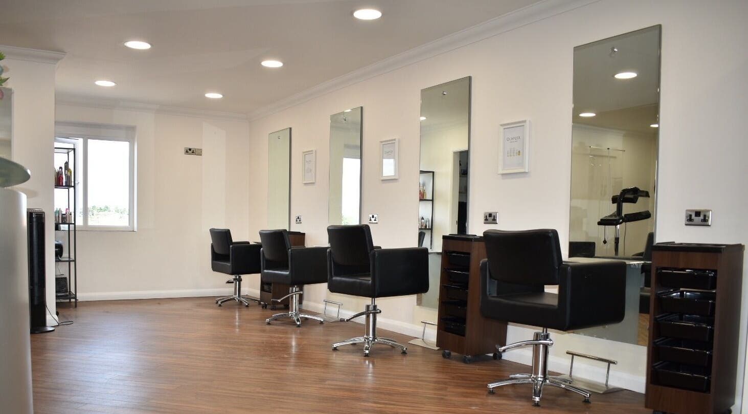 Modern salon interior at Escape Hair, Strensall, England, GB featuring sleek styling stations and mirrors.