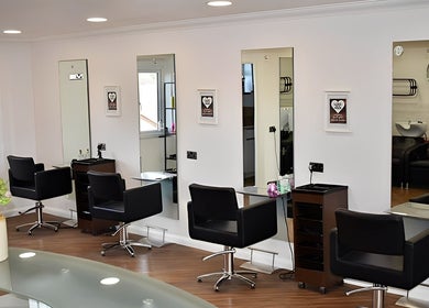 Modern salon layout at Escape Hair, Strensall, England, GB with stylish black chairs and mirrors.