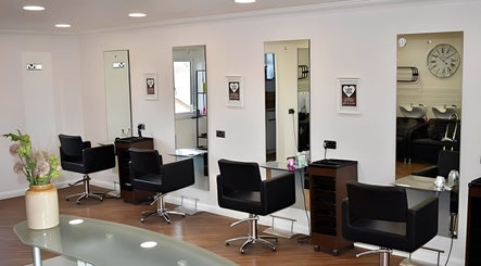 Modern salon layout at Escape Hair, Strensall, England, GB with stylish black chairs and mirrors.