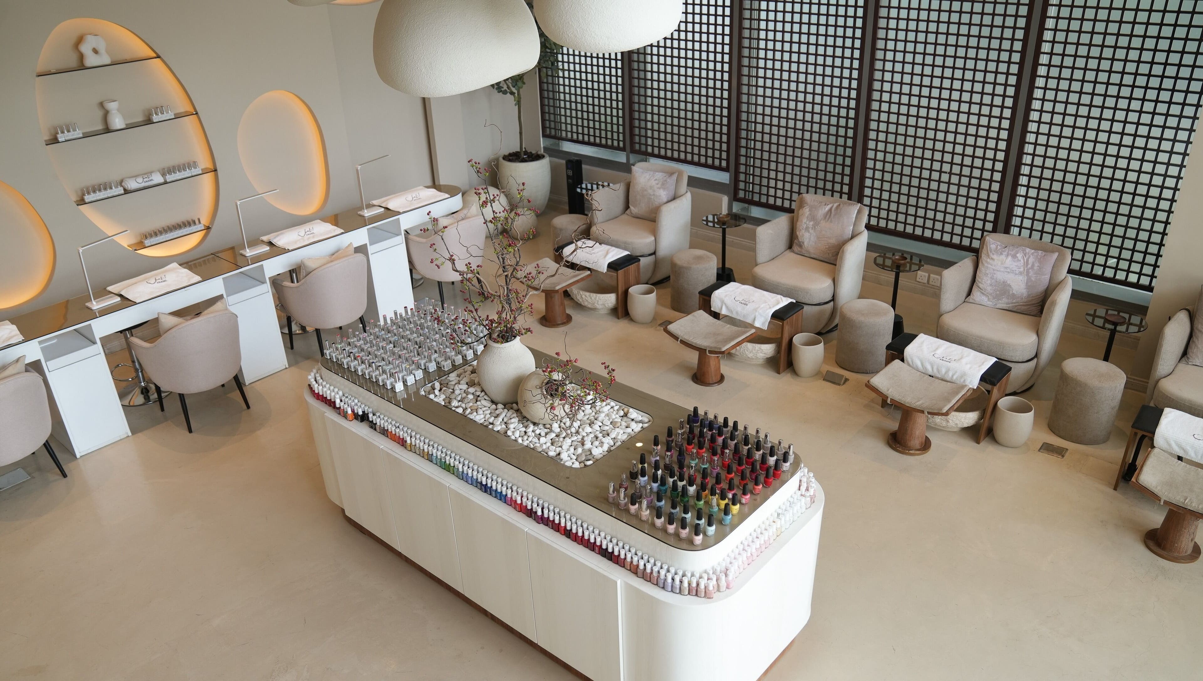 Elegant nail salon interior at Anamil Spa - Qurtubah, Riyadh. Modern design with spa chairs and nail polish display.