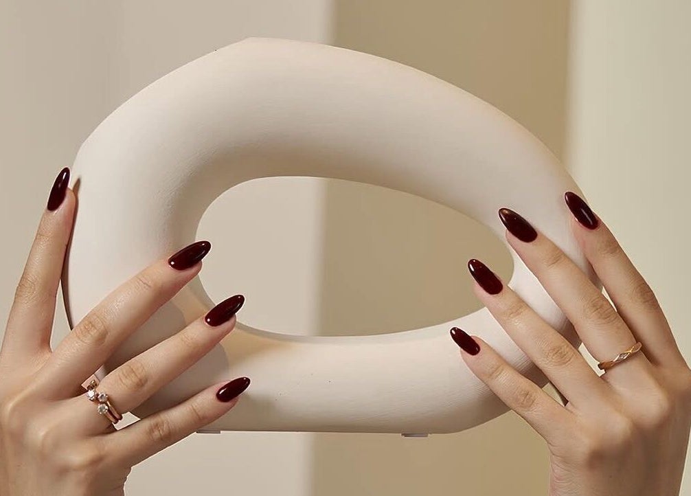 Stylish hands with burgundy nails holding art piece at Anamil Spa - Al Rabi, Riyadh, Riyadh Province, SA.