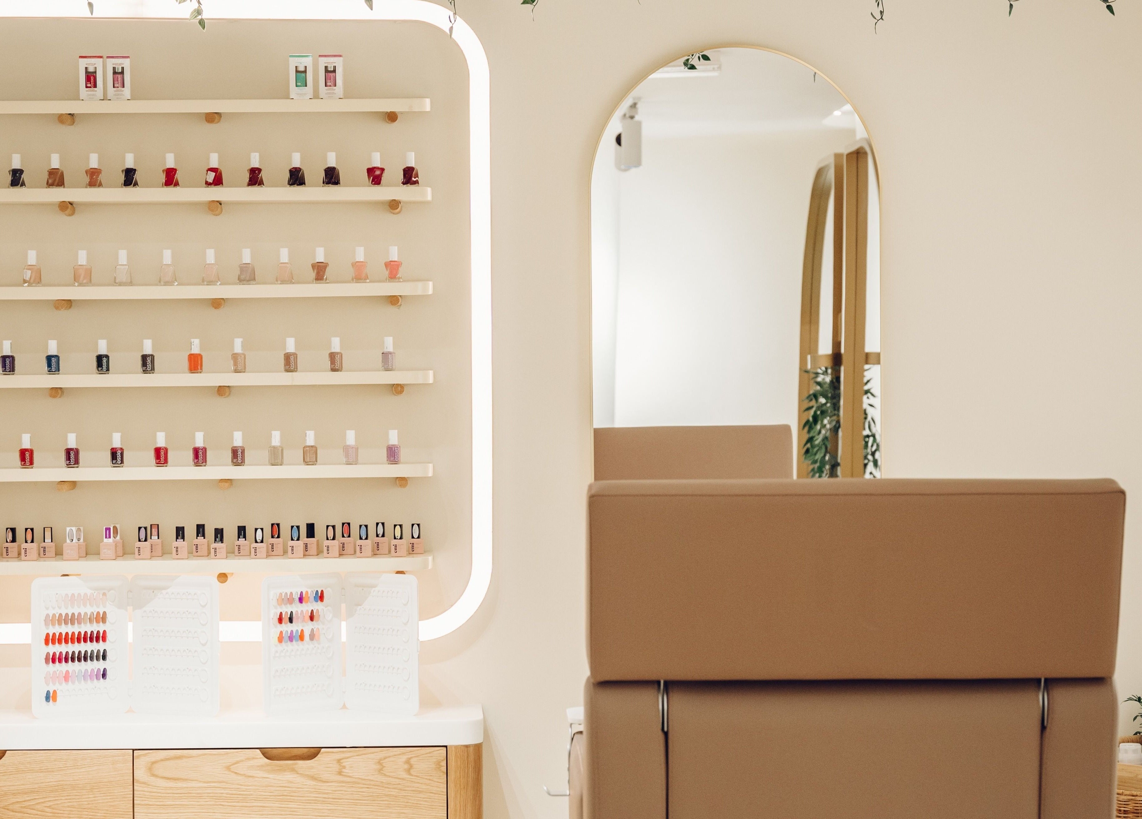 A modern nail polish display at The Hideaway, Dubai, AE with a stylish salon chair and mirror.