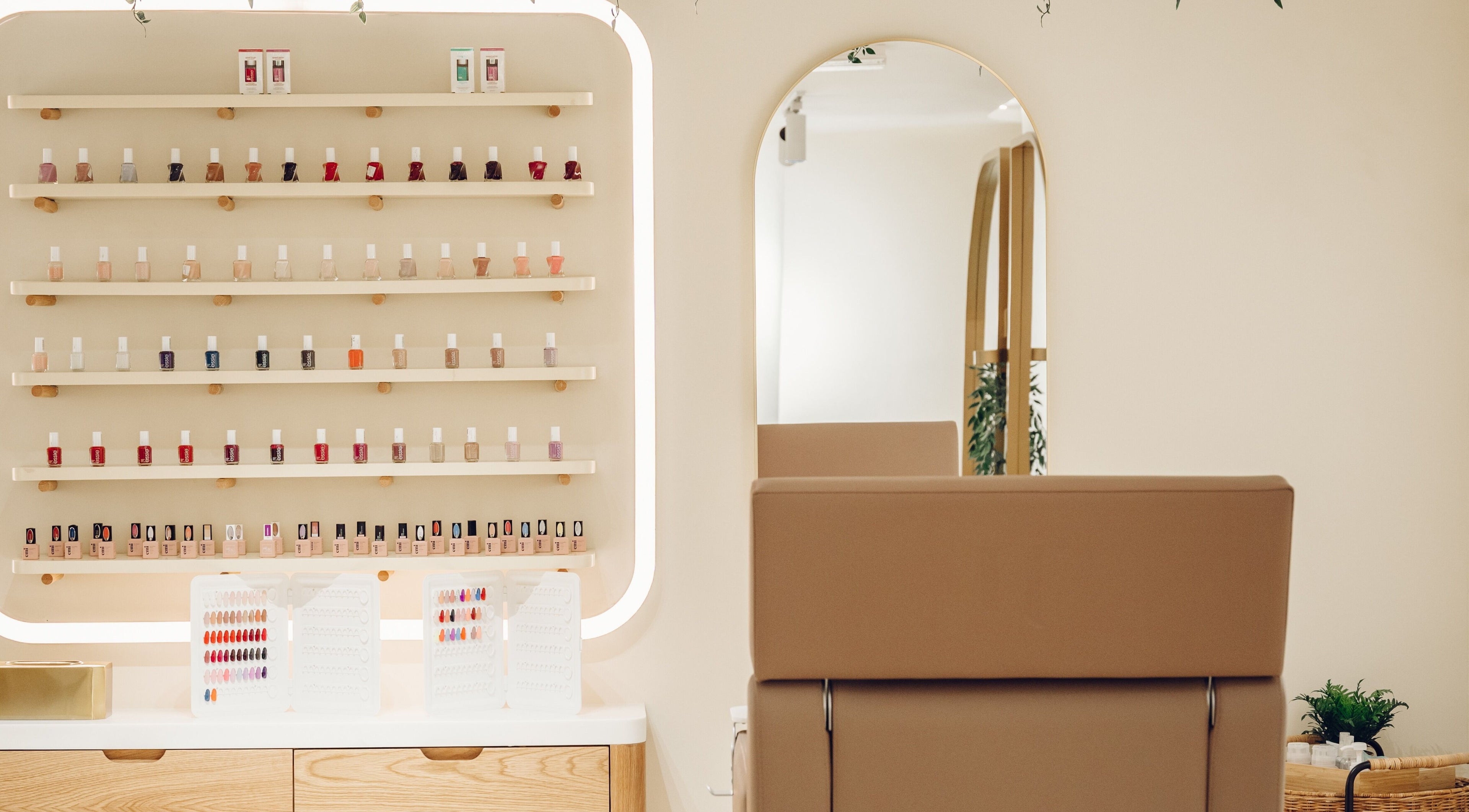 A modern nail polish display at The Hideaway, Dubai, AE with a stylish salon chair and mirror.