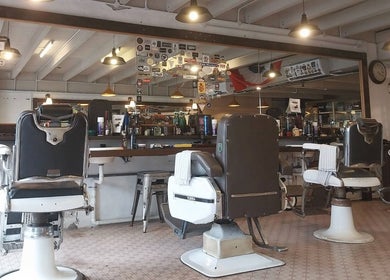 Classic barber chairs at Flesh & Blood Barber Company in Kuantan, Pahang, MY, under warm lighting.