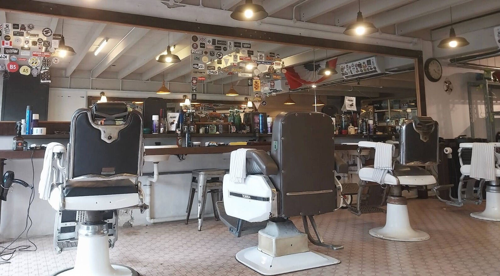 Classic barber chairs at Flesh & Blood Barber Company in Kuantan, Pahang, MY, under warm lighting.