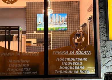 Фасадата на Evia Health & Beauty в Банско, Благоевград, BG, осветена вечерен време.