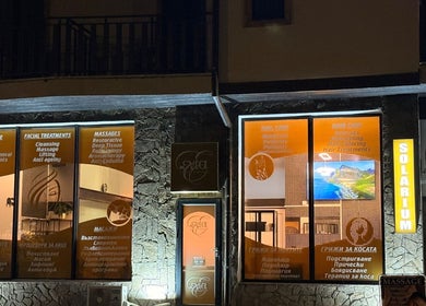 Нощен изглед на Evia Health & Beauty в Банско, Благоевград, BG, с рекламни данни за процедури.