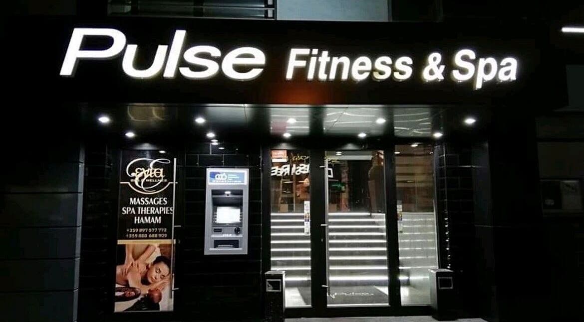 Вход на Evia Spa в Pulse Fitness Plovdiv, Пловдив, Пловдив, BG с осветено лого и стъклена врата.